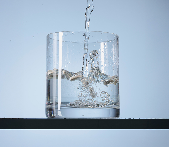 Wasser und Kapseln im Glas